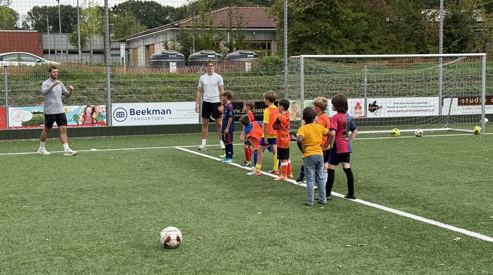 Twan en Guido geven uitleg aan een rij kinderen